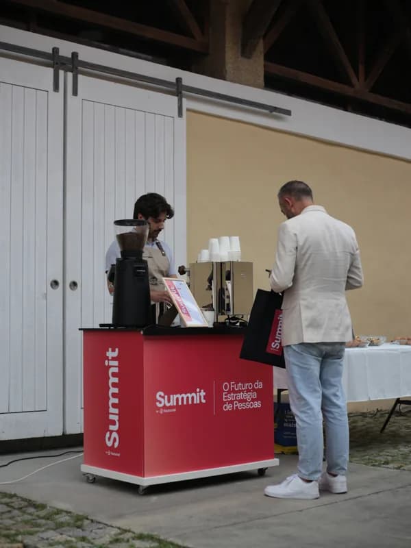 Convidado a ser servido ao balcão, com um saco do Summit by Factorial na mão.